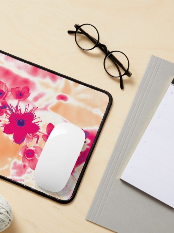 Alternative hypericum mouse pad with a white mouse sitting on it. There are also spectacles, and other office stationery in the image.