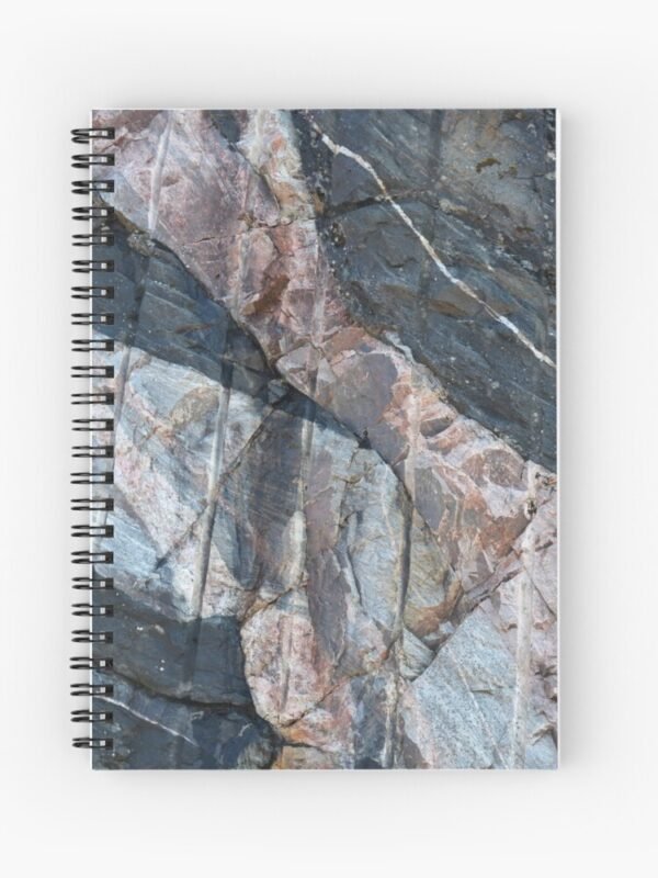 A spiral bound notebook with a closeup image of a multi-coloured rockface on its front cover