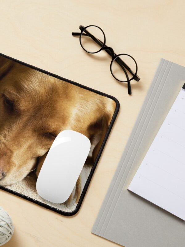 A mouse mat/pad with a photo of Willow The Wanderer, a fox red Labrador sleeping.