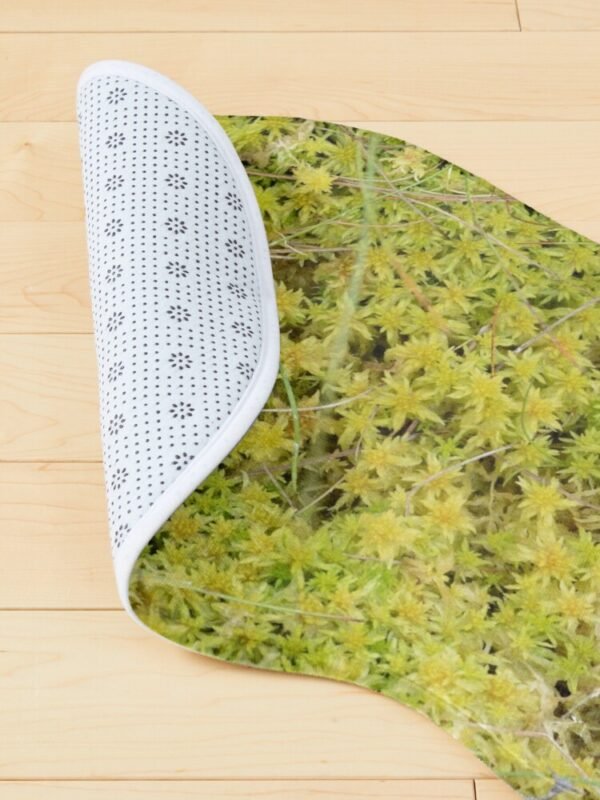 A Bed of Sphagnum Moss fish shaped pet mat with the end curled over to show the non-slip backing.