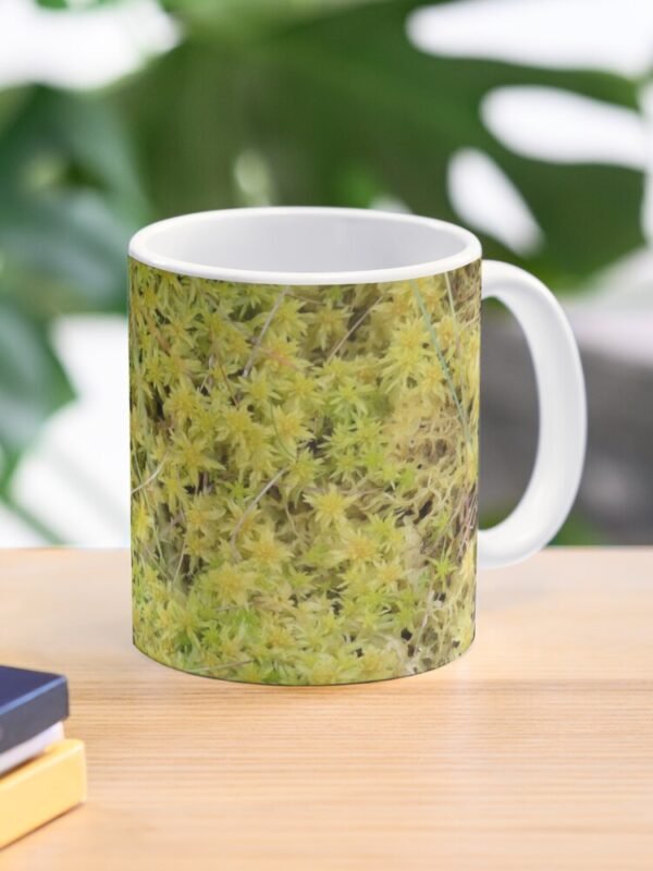 A Bed of Sphagnum Moss classic mug sitting on a desk beside some books