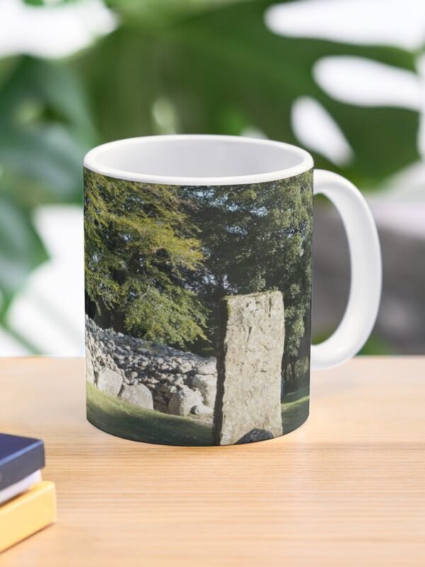 Cairns and Standing Stone Classic Mug on a desk beside some books