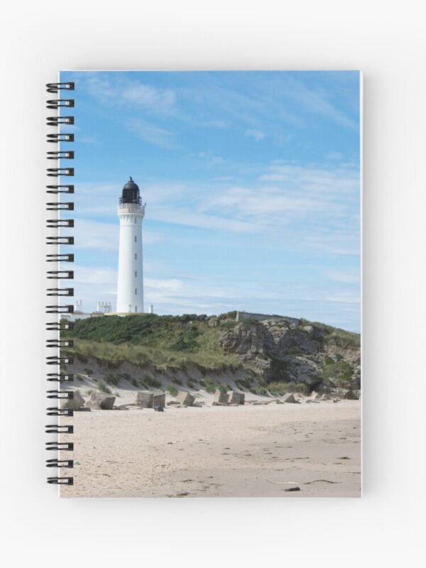 A spiral bound notebook with a front cover a photograph of a lighthouse on rocks on a beach