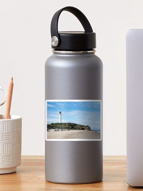 A water bottle sporting a sticker which has the Lighthouse on a beach design.