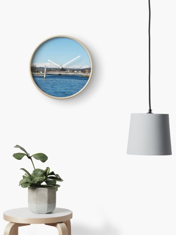 Ben Wyvis Clock on a wall beside a drop light and above a stool containing a pot plant
