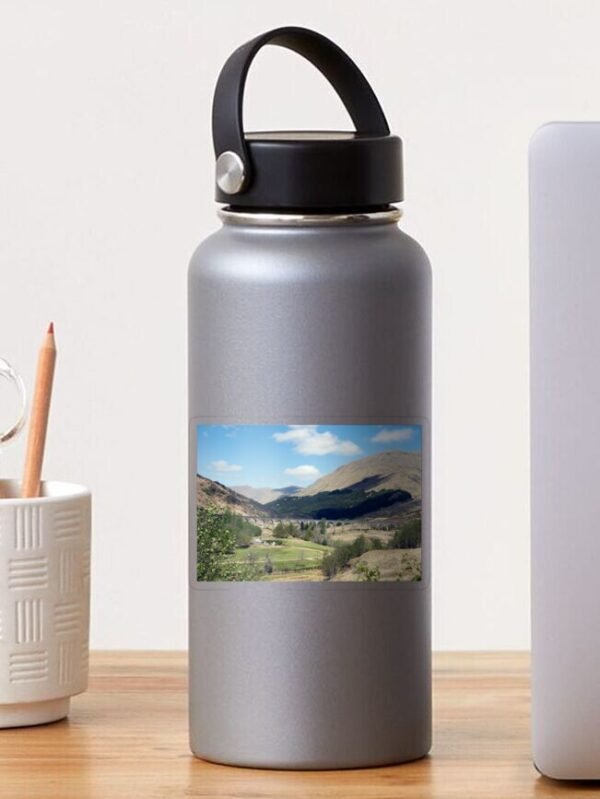 A water bottle with a transparent sticker stuck on it. The sticker has a photo of the Glenfinnan viaduct printed onto it.