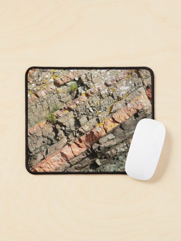 A mouse mat/pad with a close up image of different coloured layers of rock on its front