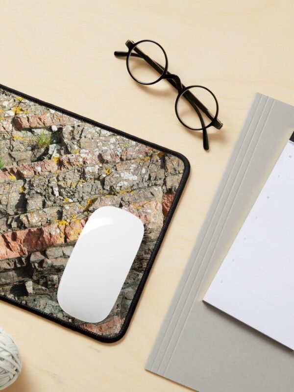 A mouse mat/pad with a close up image of different coloured layers of rock on its front