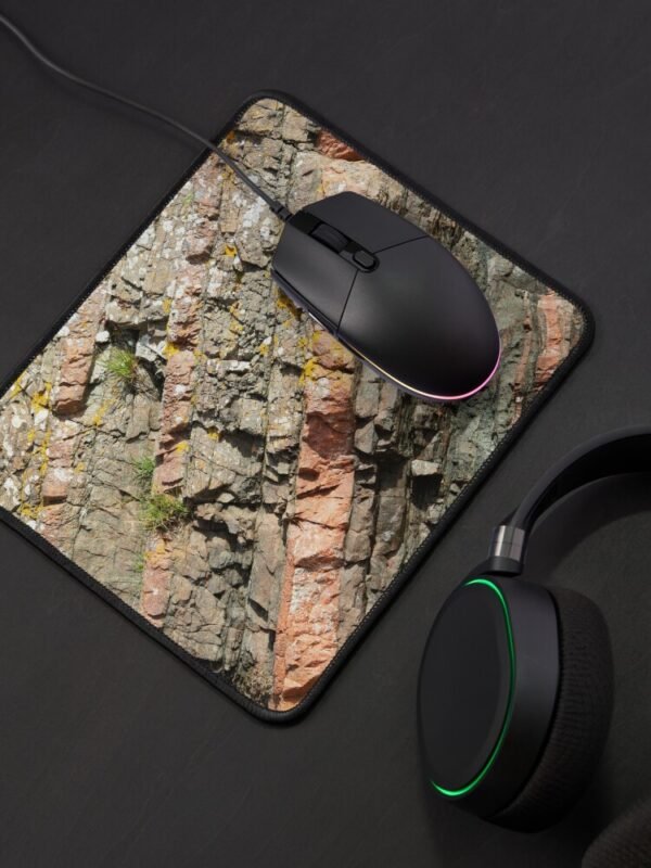 A mouse mat/pad with a close up image of different coloured layers of rock on its front